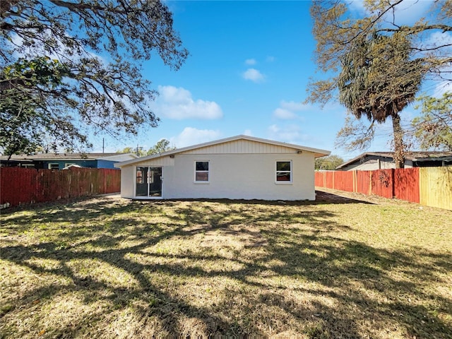 back of house featuring a fenced backyard and a yard