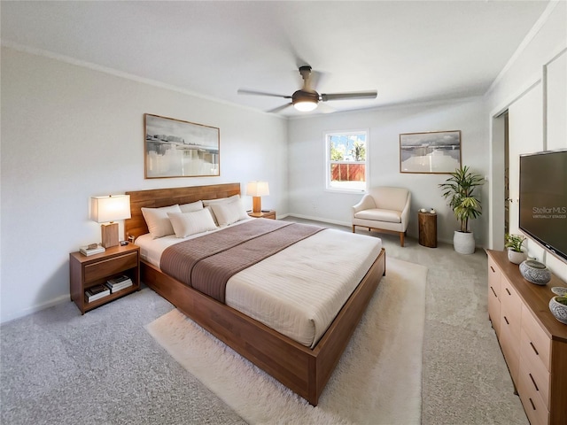 carpeted bedroom featuring ornamental molding and a ceiling fan