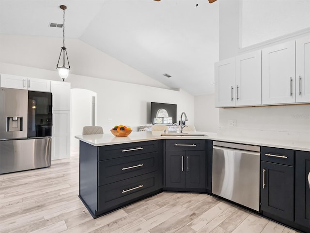 kitchen with stainless steel appliances, a peninsula, a sink, white cabinets, and light countertops