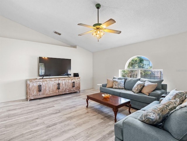 living area featuring lofted ceiling, ceiling fan, a textured ceiling, visible vents, and light wood-style floors