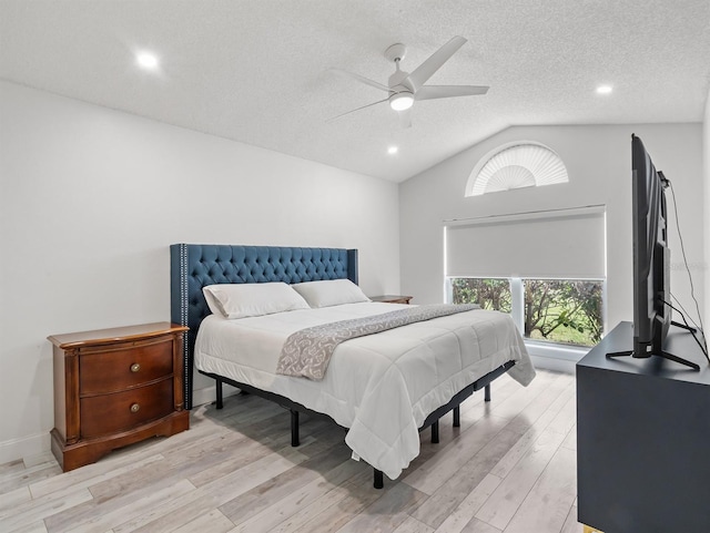 bedroom with lofted ceiling, ceiling fan, light wood-style flooring, and a textured ceiling