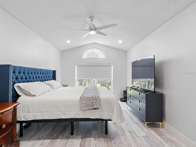 bedroom featuring light wood finished floors, baseboards, ceiling fan, vaulted ceiling, and a textured ceiling