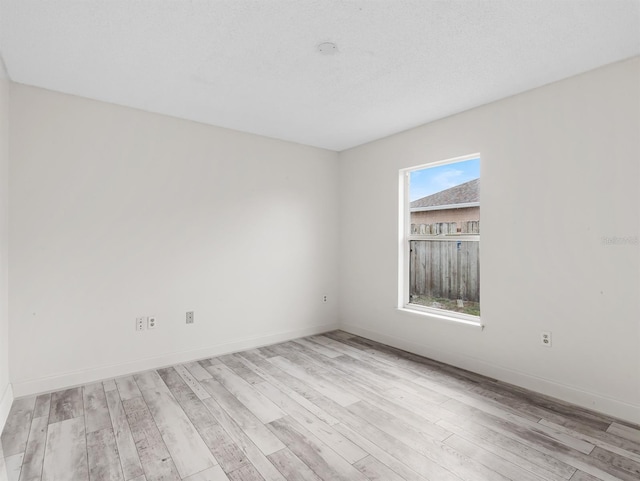 empty room with baseboards and wood finished floors