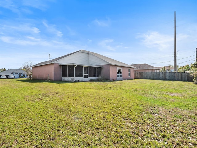 back of house with a sunroom, fence, and a yard