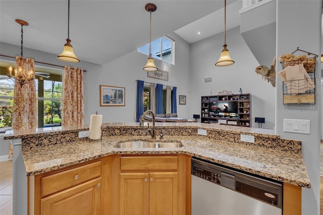 kitchen with a sink, open floor plan, stainless steel dishwasher, light stone countertops, and pendant lighting