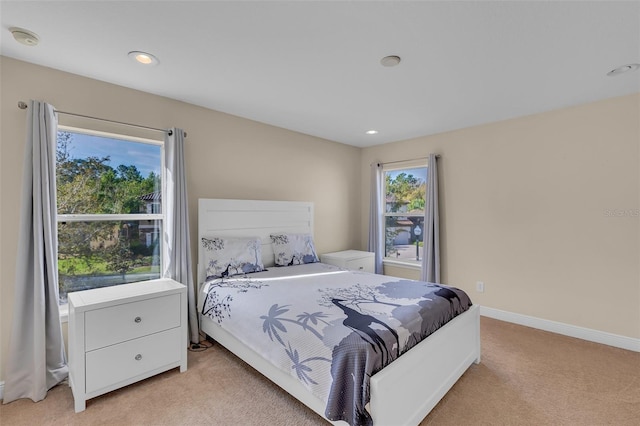 bedroom with recessed lighting, light carpet, and baseboards