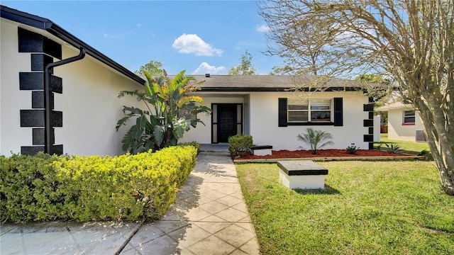 view of front of home featuring a front lawn and stucco siding