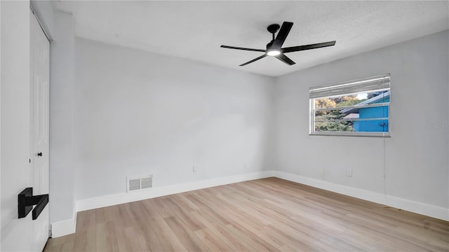 unfurnished room with a ceiling fan, baseboards, visible vents, and wood finished floors