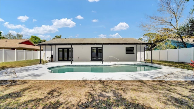 back of property with a fenced in pool, french doors, a fenced backyard, and a patio