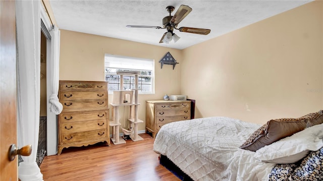 bedroom featuring a textured ceiling, ceiling fan, and wood finished floors