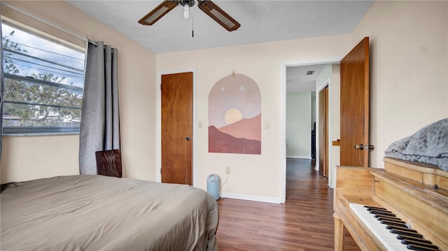 bedroom with ceiling fan, wood finished floors, and baseboards