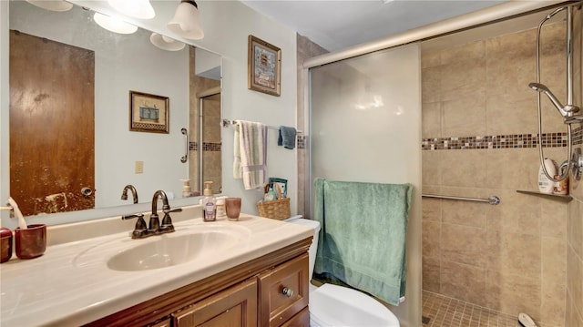 full bathroom with a stall shower, vanity, and toilet