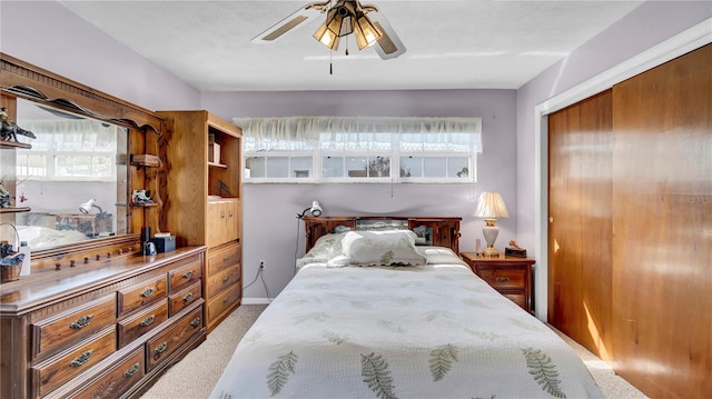 carpeted bedroom featuring ceiling fan and a closet