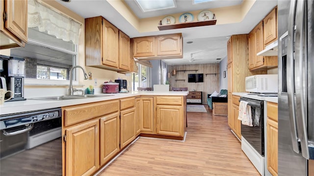 kitchen with white appliances, light countertops, a sink, and a peninsula