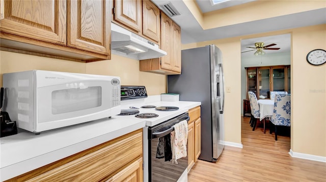 kitchen featuring white microwave, under cabinet range hood, range with electric stovetop, visible vents, and light countertops