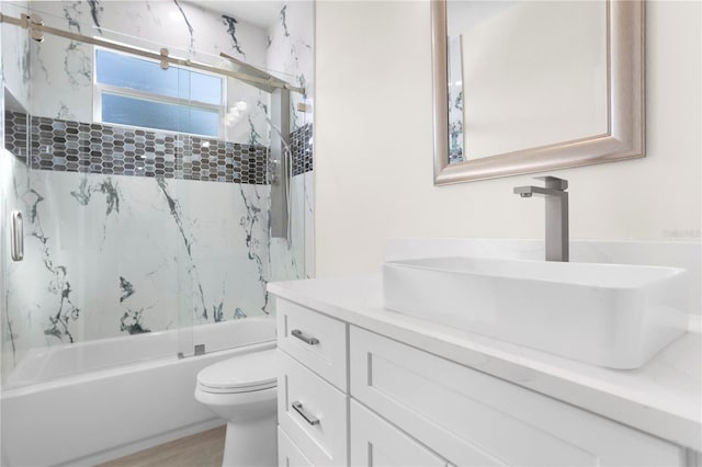 full bath featuring enclosed tub / shower combo, wood finished floors, vanity, and toilet