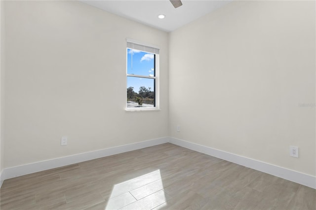 spare room featuring light wood-style floors, recessed lighting, a ceiling fan, and baseboards