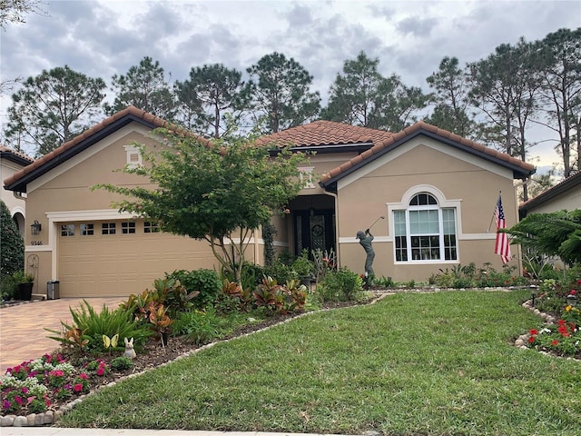 mediterranean / spanish home with a tiled roof, an attached garage, driveway, and stucco siding