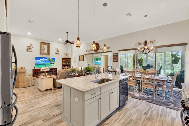 kitchen featuring light wood finished floors, visible vents, freestanding refrigerator, a sink, and dishwasher