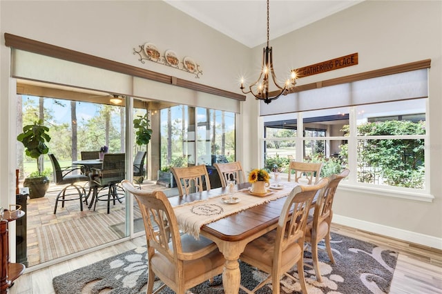 dining space featuring baseboards, a notable chandelier, and light wood finished floors