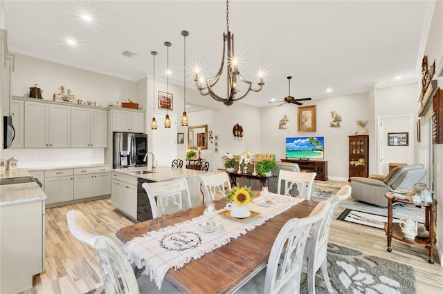 dining space with light wood finished floors, visible vents, ornamental molding, ceiling fan with notable chandelier, and recessed lighting