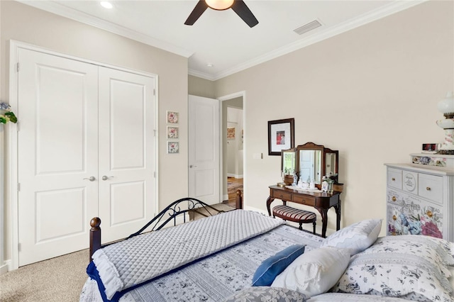 carpeted bedroom with ceiling fan, visible vents, baseboards, ornamental molding, and a closet