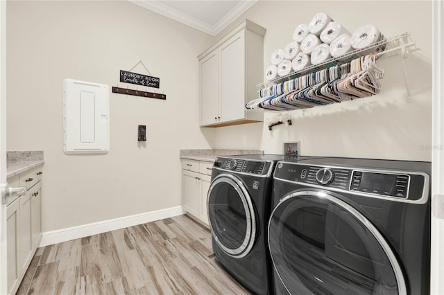 laundry room featuring washing machine and dryer, baseboards, ornamental molding, light wood-type flooring, and cabinet space