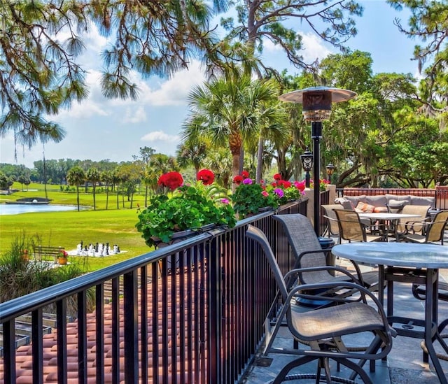 balcony with outdoor dining space and a water view