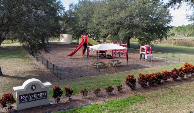 community jungle gym featuring a lawn and fence