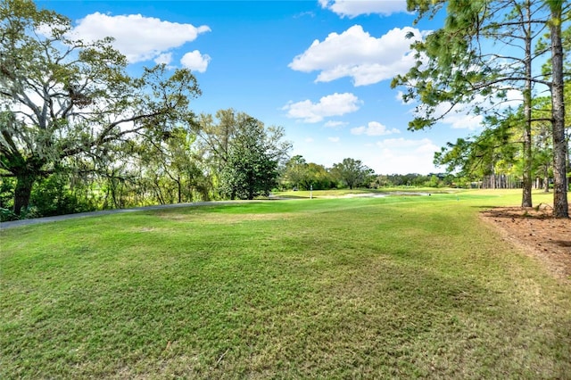 view of home's community with a yard, view of scattered trees, and golf course view