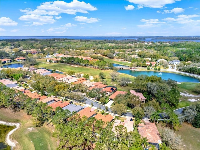 aerial view of property's location with a nearby body of water, a golf club, and nearby suburban area