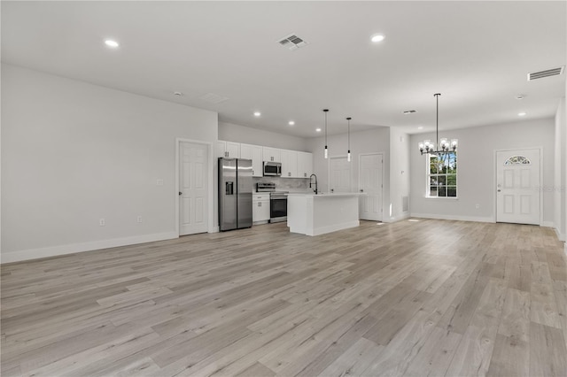 unfurnished living room with light wood finished floors, visible vents, and recessed lighting