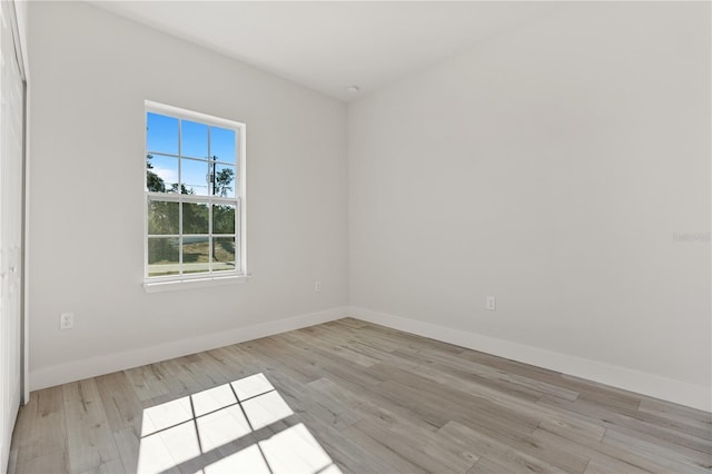 spare room with light wood-style flooring and baseboards