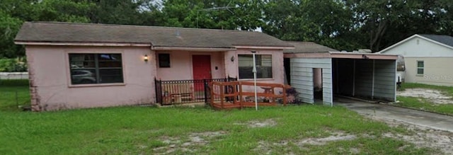 ranch-style home featuring driveway, a front lawn, and an attached carport