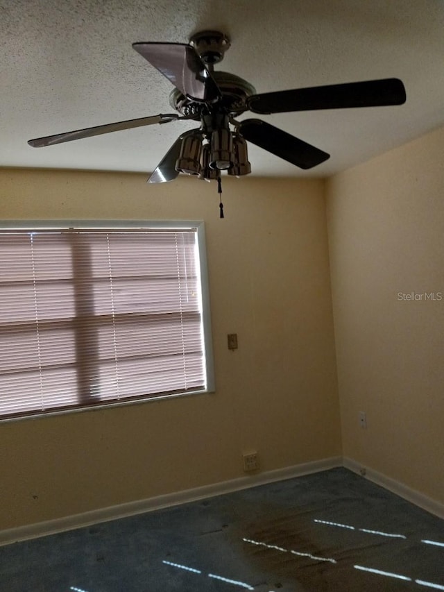 spare room featuring baseboards and a ceiling fan