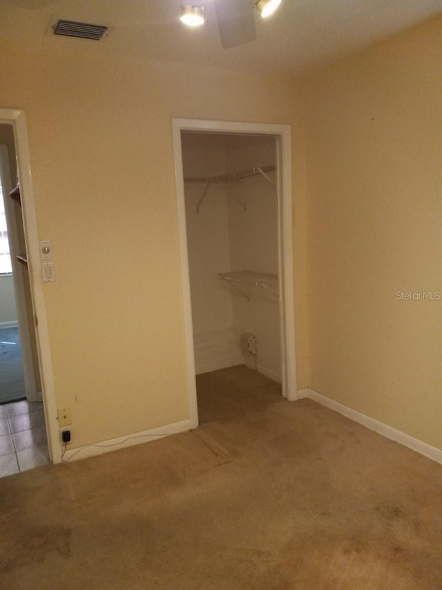 unfurnished bedroom featuring baseboards, a closet, visible vents, and light colored carpet