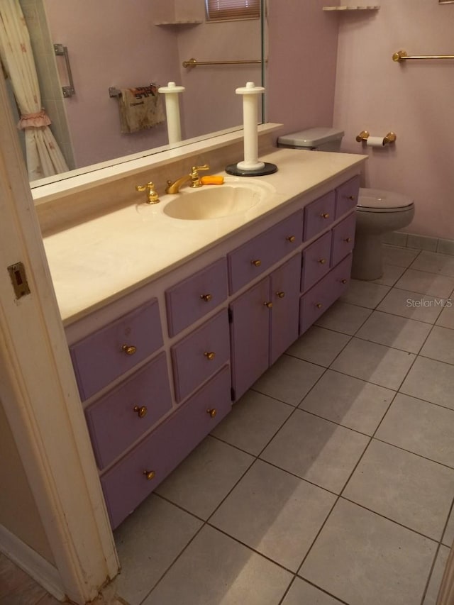 bathroom featuring tile patterned flooring, baseboards, vanity, and toilet