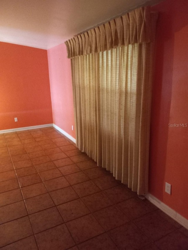 unfurnished room featuring tile patterned flooring and baseboards