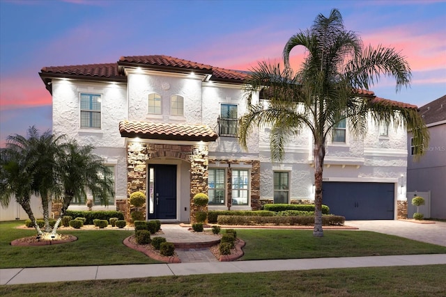 mediterranean / spanish-style home with stone siding, a yard, and stucco siding