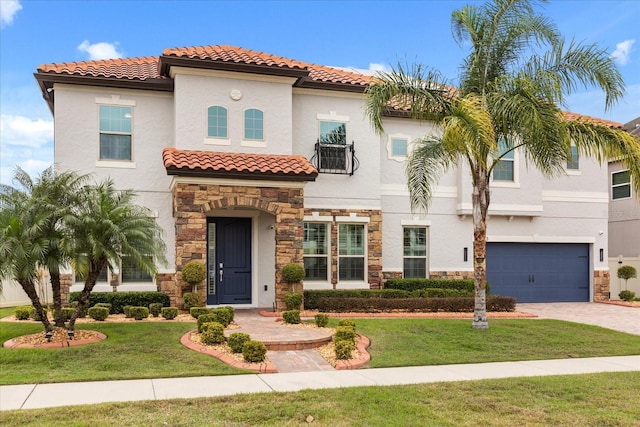 mediterranean / spanish house with an attached garage, stone siding, driveway, stucco siding, and a front yard