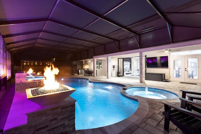 view of swimming pool featuring french doors, an outdoor fire pit, a patio area, and a pool with connected hot tub