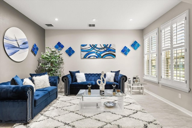 living area featuring recessed lighting, visible vents, and baseboards