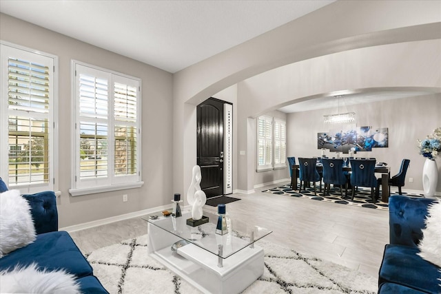 living room with arched walkways and baseboards