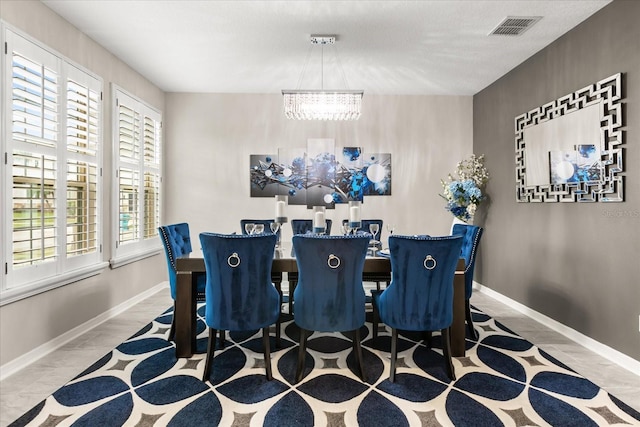 dining space featuring a chandelier, visible vents, and baseboards