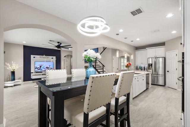 kitchen with visible vents, white cabinets, arched walkways, stainless steel appliances, and light countertops