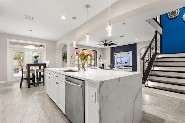 kitchen with arched walkways, visible vents, stainless steel dishwasher, a sink, and light stone countertops