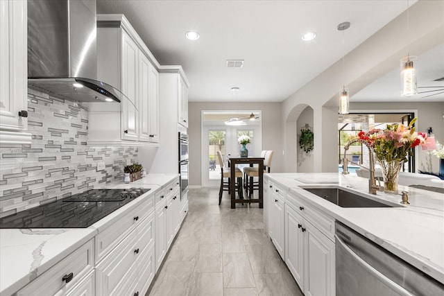 kitchen with stainless steel appliances, visible vents, white cabinetry, wall chimney range hood, and decorative light fixtures