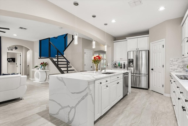 kitchen with appliances with stainless steel finishes, arched walkways, visible vents, and a sink