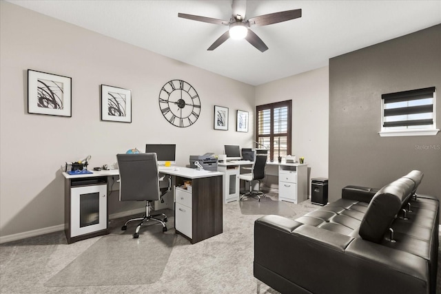 home office featuring light carpet, baseboards, and a ceiling fan