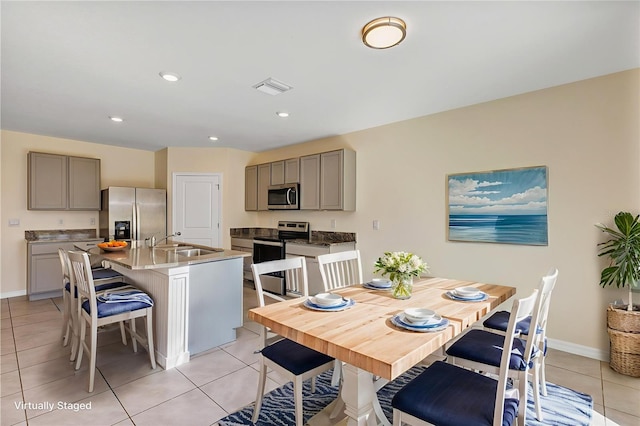 39 Hickory Course Way, Ocala, FL 34472 - kitchen with appliances with stainless steel finishes, gray cabinetry, a breakfast bar, a sink, and recessed lighting